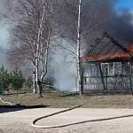 Под Великим Новгородом догорает дом. По сухой траве огонь может добраться до соседей